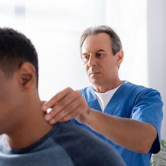 Лікар проводить діагностичний огляд пацієнта з болем у шиї